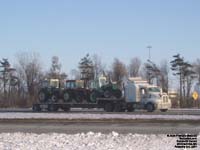 A Kenworth truck pulls three farm tractors