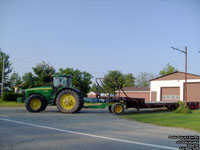 John Deere tractor and empty hay trailer